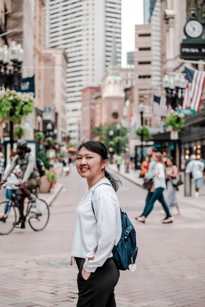 Woman smiles in bustling Boston