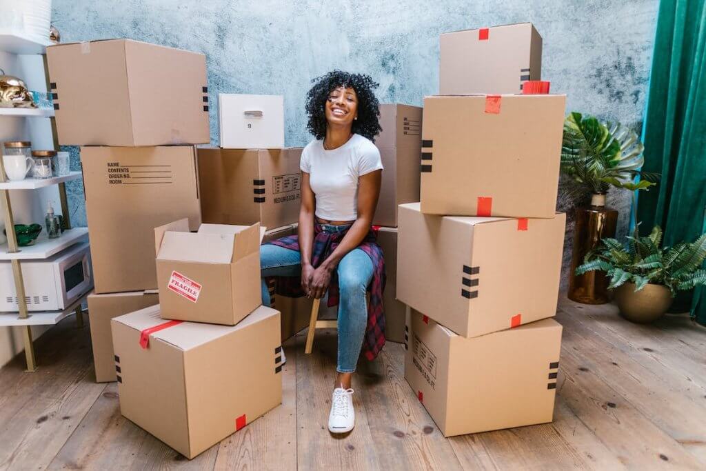 woman sitting in between moving boxes