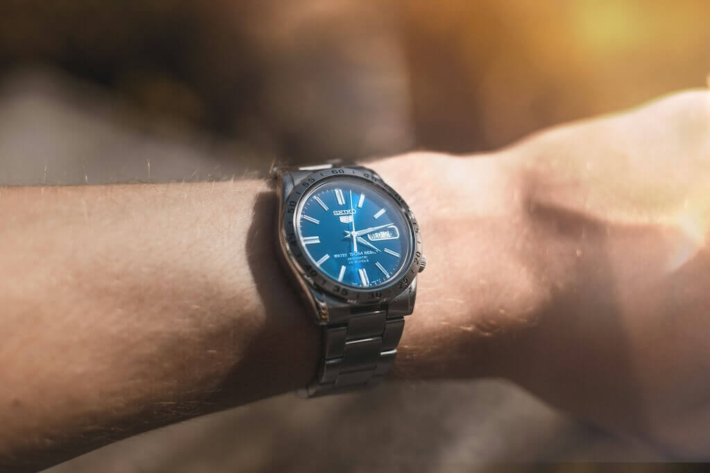 watch with blue face on a person's arm