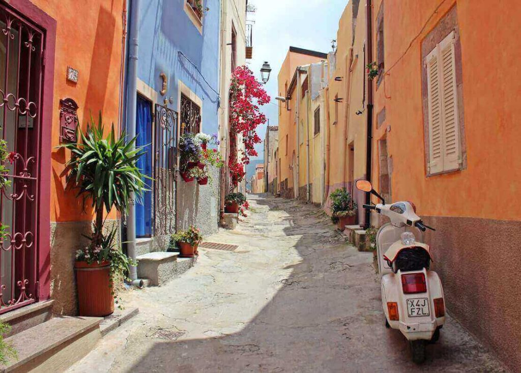 A picture of the colourful buildings, flowers, and motor scooters in Italy